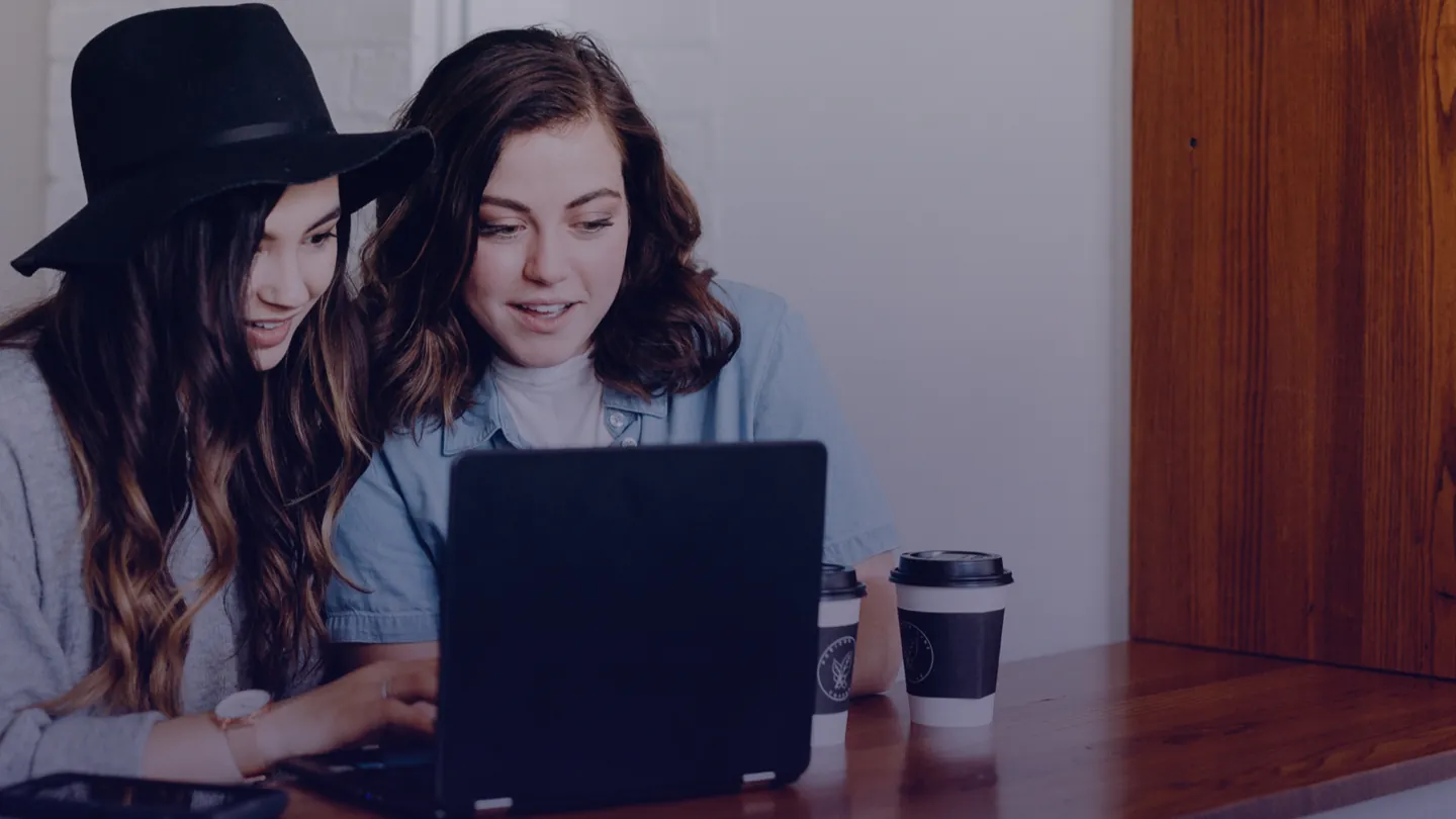 Twee leerlingen bekijken samen uitleg op een laptop